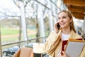 Happy young woman talking on phone making call standing indoors. Copy space Royalty Free Stock Photo