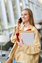 Happy girl student talking on phone making call standing indoors. Royalty Free Stock Photo