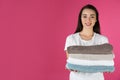 Happy young woman holding clean towels on color background. Laundry day Royalty Free Stock Photo