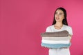 Happy young woman holding clean towels on color background. Laundry day Royalty Free Stock Photo