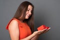 Beautiful woman opens a box with a gift. Happy young woman holding a gift