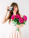 Happy young woman holding in hands peony bouquet and old vintage camera. Sweet romantic moment. Smiling woman Royalty Free Stock Photo