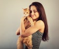 Happy young woman holding and hugging with love on the hands her red maine coon kitten and kissing. Closeup Royalty Free Stock Photo