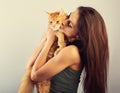 Happy young woman holding and hugging with love on the hands her red maine coon kitten and kissing. Closeup Royalty Free Stock Photo