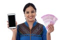 Happy young woman holding Indian currency and cellphone Royalty Free Stock Photo