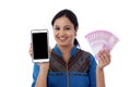 Happy young woman holding Indian currency and mobile phone Royalty Free Stock Photo