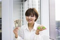 Happy young woman holding Japanese Yen and toy car Royalty Free Stock Photo