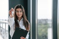 Happy young woman is holding keys for the new apartment. Standing on the construction site Royalty Free Stock Photo