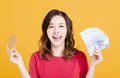 Happy young woman holding money and credit card