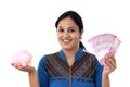 Happy young woman holding a piggy bank and Indian rupee notes Royalty Free Stock Photo