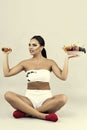 Happy young woman holding a plate with fruits in one hand and du Royalty Free Stock Photo