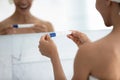 Happy young woman holding pregnancy positive test in bathroom