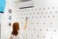 Happy Young Woman Holding Remote Control Relaxing Under The Air Conditioner. Royalty Free Stock Photo