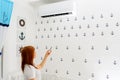 Happy Young Woman Holding Remote Control Relaxing Under The Air Conditioner. Royalty Free Stock Photo