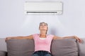 Woman Relaxing Under The Air Conditioner Royalty Free Stock Photo