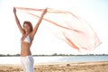 Happy young woman holding scarf on beach Royalty Free Stock Photo