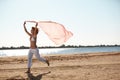 Happy young woman holding scarf on beach Royalty Free Stock Photo