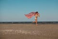 Happy young woman holding scarf on beach Royalty Free Stock Photo