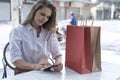 Happy young woman holding shopping bags and mobile phone. Makes online shopping on a mobile phone Royalty Free Stock Photo