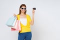 Happy young woman holding shopping bags and showing credit card isolated on white background Royalty Free Stock Photo