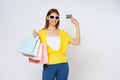 Happy young woman holding shopping bags and showing credit card isolated on white background Royalty Free Stock Photo