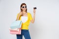 Happy young woman holding shopping bags and showing credit card isolated on white background Royalty Free Stock Photo