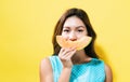 Happy young woman holding a slice of cantaloupe