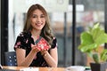 Young woman holding small house model and smiling at camera. Real estate investment concept. Royalty Free Stock Photo