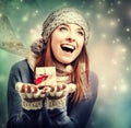 Happy young woman holding a small present box