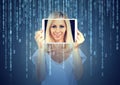 Happy young woman holding tablet with her face displayed on a screen isolated on binary code background Royalty Free Stock Photo