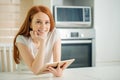 Happy young woman holding tablet and looking at camera Royalty Free Stock Photo