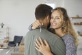 Happy young woman hugging her husband, holding key to their new house and smiling Royalty Free Stock Photo