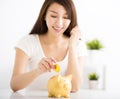 Happy young woman Inserting Coin In Piggy bank Royalty Free Stock Photo