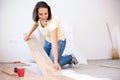 Happy young woman installing laminate flooring in new apartment or house Royalty Free Stock Photo