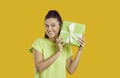 Happy young woman isolated on yellow background trying to guess what's inside her present Royalty Free Stock Photo