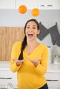 happy young woman joggling with oranges in kitchen Royalty Free Stock Photo