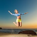 Happy young woman jumping on beach Royalty Free Stock Photo