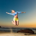 Happy young woman jumping on beach Royalty Free Stock Photo