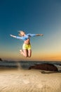 Happy young woman jumping on beach Royalty Free Stock Photo