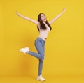 Happy  young woman  jumping and celebrating  isolated over yellow Royalty Free Stock Photo