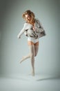 Happy young woman jumping high on gray background Royalty Free Stock Photo