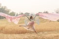 Happy young woman jumping over summer yellow field with golden wheat. Royalty Free Stock Photo