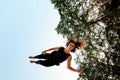 Happy young woman jumping and tumbling in the air against the blue sky. Royalty Free Stock Photo