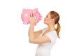 Happy young woman kissing a piggybank Royalty Free Stock Photo
