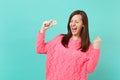 Happy young woman in knitted pink sweater screaming doing winner gesture hold in hand bitcoin, future currency isolated