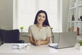 Happy woman with laptop looking at camera indoors. Business lady working online from home. Student on remote learning