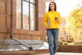 Happy young woman with laptop and paper cup of coffee walking outdoors Royalty Free Stock Photo