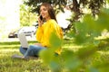 Happy young woman with laptop talking on phone in park Royalty Free Stock Photo