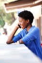 Happy young woman laughing and talking on mobile phone at cafe outdoors Royalty Free Stock Photo