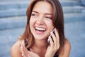 Happy young woman laughing while talking on the phone on the street Royalty Free Stock Photo